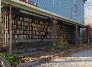 Paperbacks are stored and sold by the honor system from an outdoor bookstall on the side of the building.