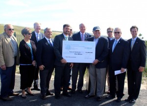 CCB MEDIA FILE PHOTO State Secretary of Energy and Environmental Affairs Matthew Beaton poses on September 22 with a large-scale $1 million check to go toward beach nourishment at Town Neck Beach. Standing with him are the five members of the Sandwich Board of Selectmen, Town Manager George "Bud" Dunham, State Representative Randy Hunt, State Senator Vinny deMacedo and US Congressman Bill Keating.
