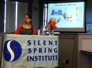 Janet Ackerman stands in front of a map showing cancer rates in the region.