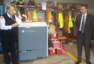 Sandwich Deputy Fire Chief John Burke (right), stands next to the Sterilis Needle Disposal System with Sterilis CEO Bob Winskowicz.